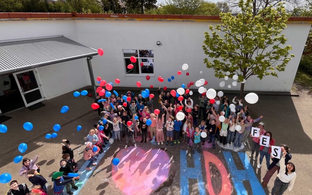 Luftaufnahme der Schülerinnen und Schüler der FES Grundschule Heidenheim auf ihrem Schulhof mit Ballons