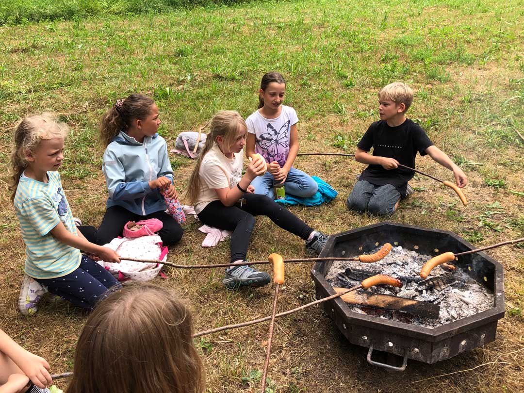 Kinder der FES Heidenheim Grundschule braten am Waldtag "Würschdle" über dem Feuer