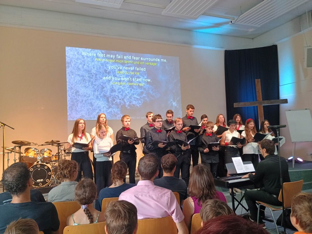 FES-Jugendchor auf Gemeindetour: Chormusik und Worship in der ev. Christusgemeinde (FeG) Steinheim am Albuch
Seit vielen Jahren schon gestalten Schülerinnen und Schüler in den unterschiedlichen Chören und Vokalensembles der FES-Realschule und des FES-Gymnasiums im Laufe eines Schuljahres Gottesdienste in und um Heidenheim musikalisch mit oder treten mit einem musikalischen Programm in sozialen Einrichtungen der Region auf. 