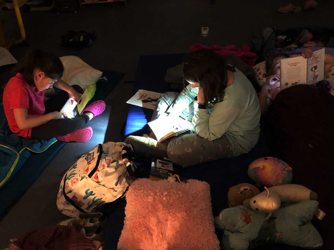 Lesenacht1 Kinder lesen mit Taschenlampen bei der Lesenacht der FES Grundschule.