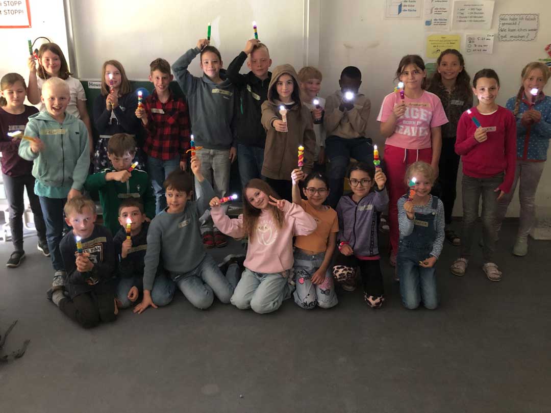 Kinder Zeigen ihre selbstgebauten Taschenlampen.